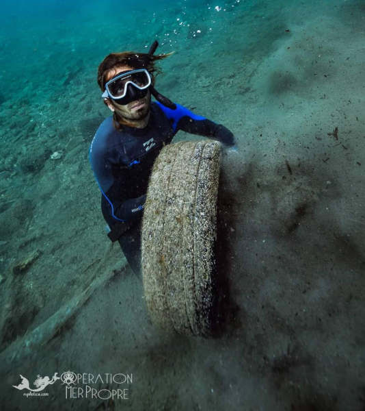 Ramassage d'un vieux pneu abandonné dans la mer