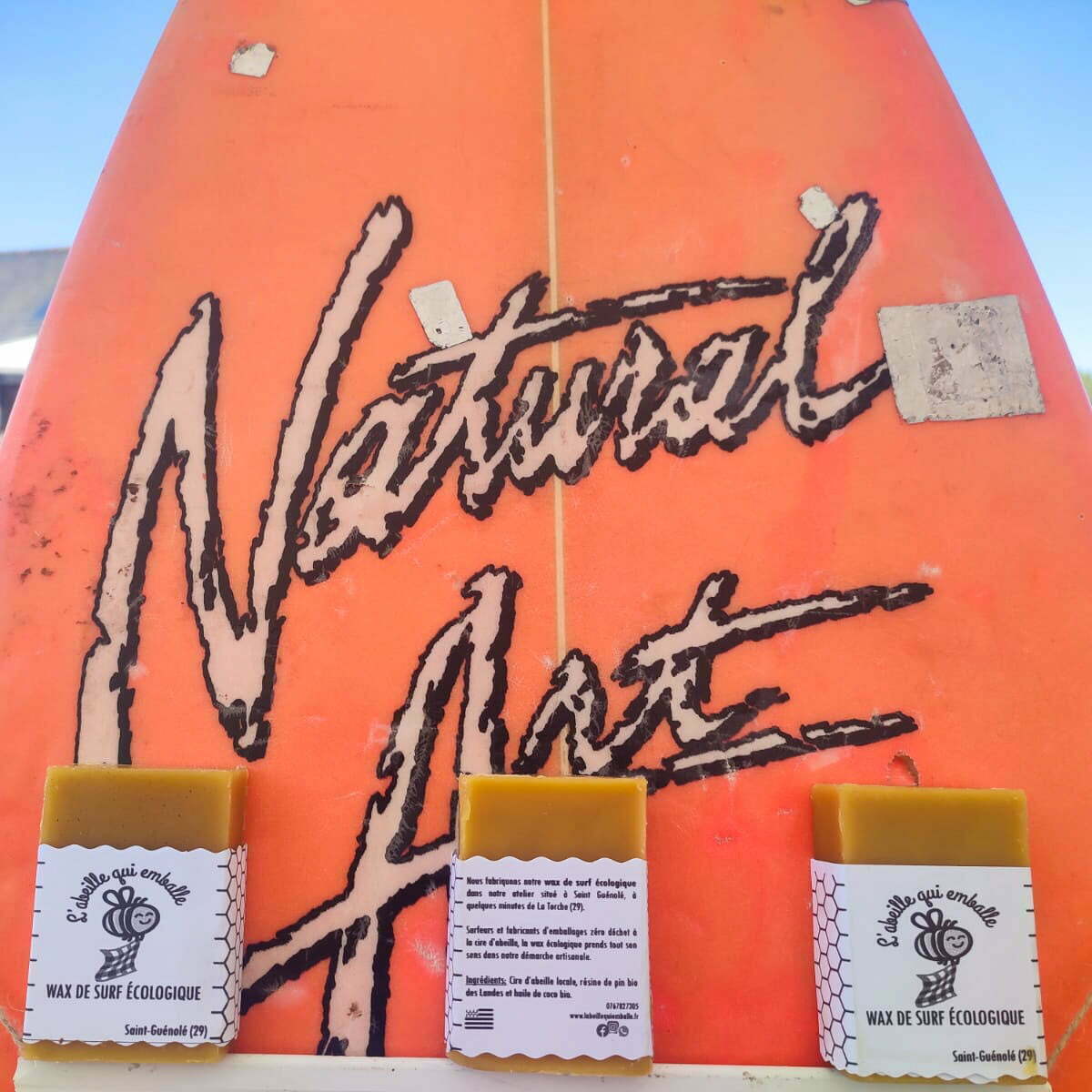 blocs de wax de surf écologique de L'abeille qui emballe exposés sur une planche de surf