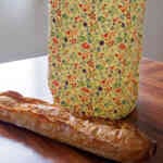 Sac à pain en cire d'abeille (motif petites fleurs bleues) avec une baguette de pain